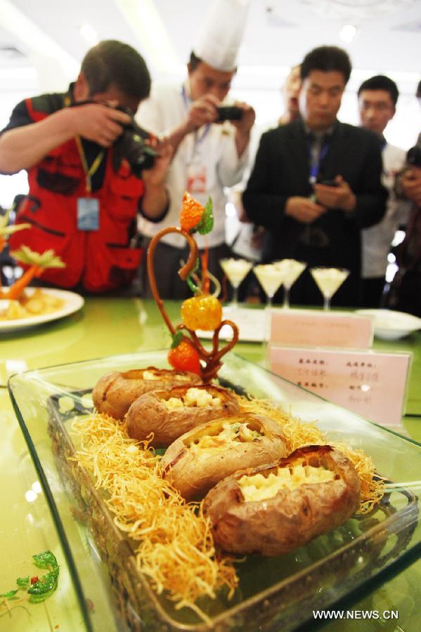 Visitors take photos of a dish made of potatoes during a potato festival in Tengzhou City, east China's Shandong Province, April 13, 2013. (Xinhua/Song Haicun) 