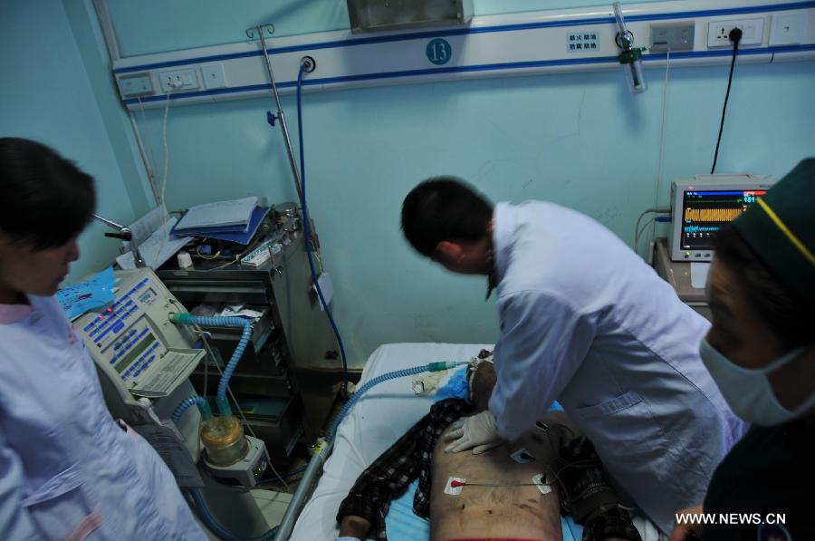 An injured person receives medical treatment in hospital after a fire broke out in a hotel in the Fancheng District of Xiangyang City, central China's Hubei Province, April 14, 2013. Fourteen people have been confirmed dead and 50 others injured in the hotel fire that occurred on Sunday morning. (Xinhua)  