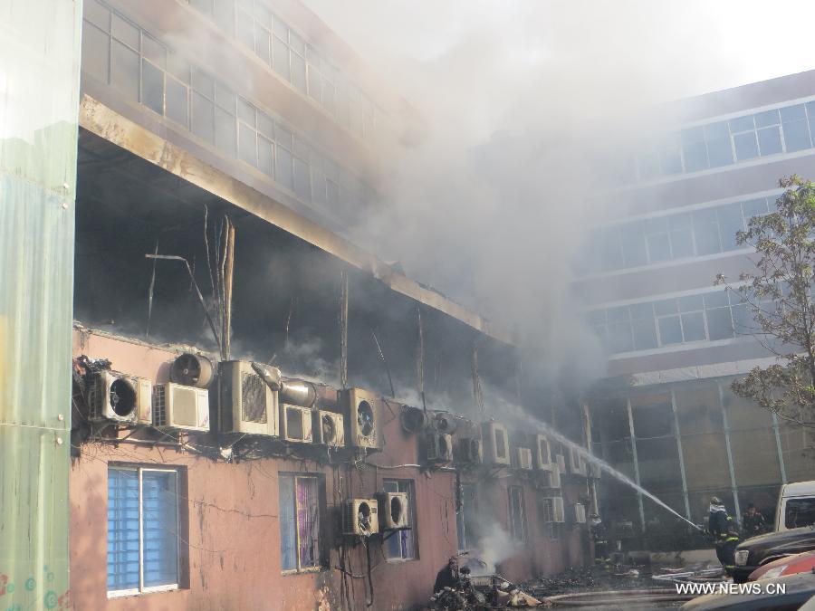 Firefighters work at the accident site after a fire broke out in a hotel in the Fancheng District of Xiangyang City, central China's Hubei Province, April 14, 2013. Fourteen people have been confirmed dead and 50 others injured in the hotel fire that occurred on Sunday morning. (Xinhua)