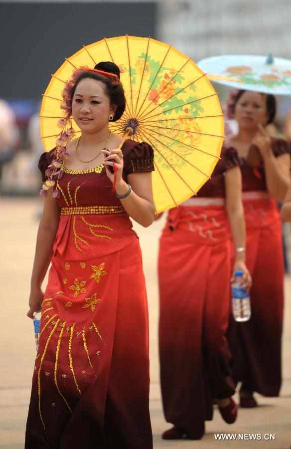 People perform a traditional umbrella dance to celebrate the Water Splashing Festival, also the New Year of the Dai ethnic group, in Jinghong City, Dai Autonomous Prefecture of Xishuangbanna, southwest China's Yunnan Province, April 14, 2013. (Xinhua/Qin Qing) 