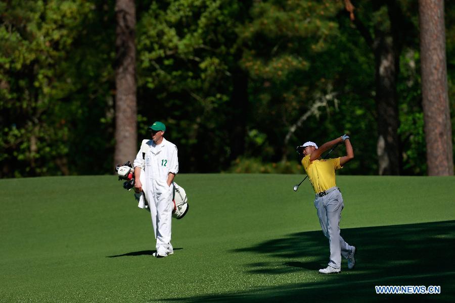 China's Guan Tianlang (R) competes during the third round of the 2013 Masters golf tournament at the Augusta National Golf Club in Augusta, Georgia, the United States, April 13, 2013. Guan shot a five-over par 77 Saturday. (Xinhua/Chris Trotman/Augusta National)