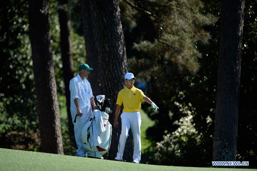 China's Guan Tianlang (R) gestures during the third round of the 2013 Masters golf tournament at the Augusta National Golf Club in Augusta, Georgia, the United States, April 13, 2013. Guan shot a five-over par 77 Saturday. (Xinhua/Charles Laberge/Augusta National)