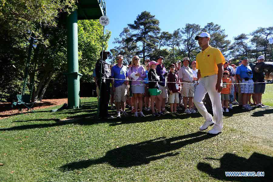 China's Guan Tianlang (Front) walks from the first green during the third round of the 2013 Masters golf tournament at the Augusta National Golf Club in Augusta, Georgia, the United States, April 13, 2013. Guan shot a five-over par 77 Saturday. (Xinhua/Chris Trotman/Augusta National)