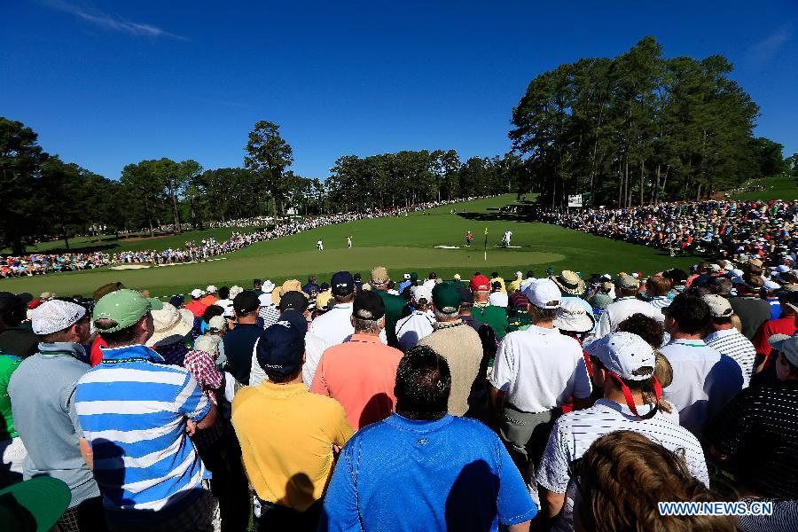 Audience watch China's Guan Tianlang hitting during the third round of the 2013 Masters golf tournament at the Augusta National Golf Club in Augusta, Georgia, the United States, April 13, 2013. Guan shot a five-over par 77 Saturday. (Xinhua/Chris Trotman/Augusta National)