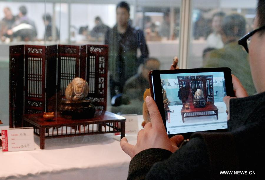 A man takes pictures of a jade sculpture at the 2013 Beijing International Jewelry Exhibition in Beijing, capital of China, April 14, 2013. The four-day exhibition, which kicked off on April 12 at China International Exhibition Center, attracted more than 800 exhibitors both home and abroad. (Xinhua/Chen Sihan) 