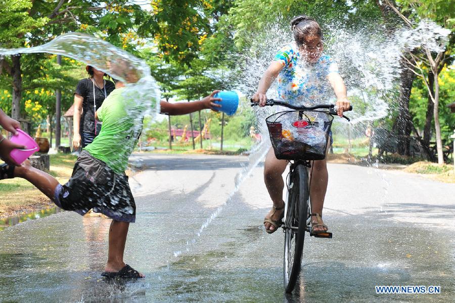 A cyclist is splashed during celebrations for Songkran Festival, Thailand's traditional New Year Festival, at the Ancient City in Samut Prakan Province, Thailand, April 14, 2013. Songkran, also known as the Water Splashing Festival, started here on April 13 this year. (Xinhua/Rachen Sageamsak)