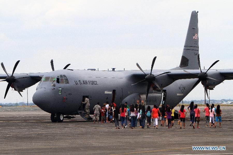 Visitors walk in front of the Lockheed C-130 during an aircraft static display as part of a joint military exercise in Pampanga Province, the Philippines, April 13, 2013. The Philippines and the U.S. held their 29th annual joint military exercise with at least 8,000 American and Filipino soldiers participating in the training. The joint military exercise, more known as Balikatan, which means "shoulder-to-shoulder" in Filipino, is held from April 5 to 17. (Xinhua/Rouelle Umali)