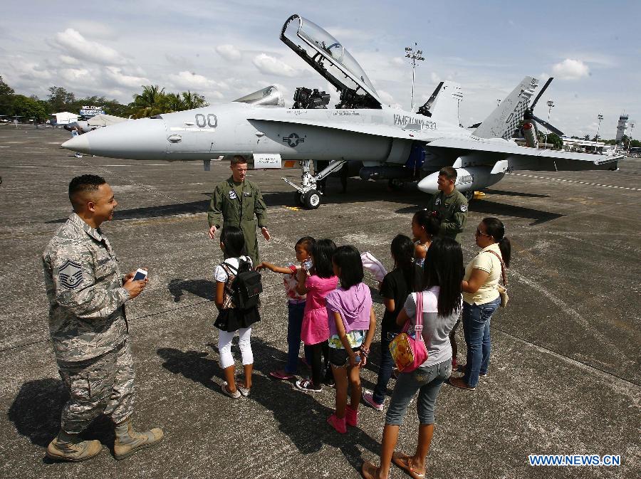 U.S. Air Force pilots interact with children in front of the F/A-18 Hornet during an aircraft static display as part of a joint military exercise in Pampanga Province, the Philippines, April 13, 2013. The Philippines and the U.S. held their 29th annual joint military exercise with at least 8,000 American and Filipino soldiers participating in the training. The joint military exercise, more known as Balikatan, which means "shoulder-to-shoulder" in Filipino, is held from April 5 to 17. (Xinhua/Rouelle Umali)