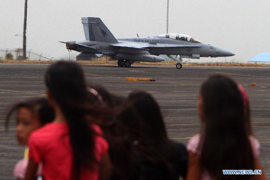 Children watch an F/A-18 Hornet jet as it prepares to take off during an aircraft static display as part of a joint military exercise in Pampanga Province, the Philippines, April 13, 2013. The Philippines and the U.S. held their 29th annual joint military exercise with at least 8,000 American and Filipino soldiers participating in the training. The joint military exercise, more known as Balikatan, which means "shoulder-to-shoulder" in Filipino, is held from April 5 to 17. (Xinhua/Rouelle Umali)