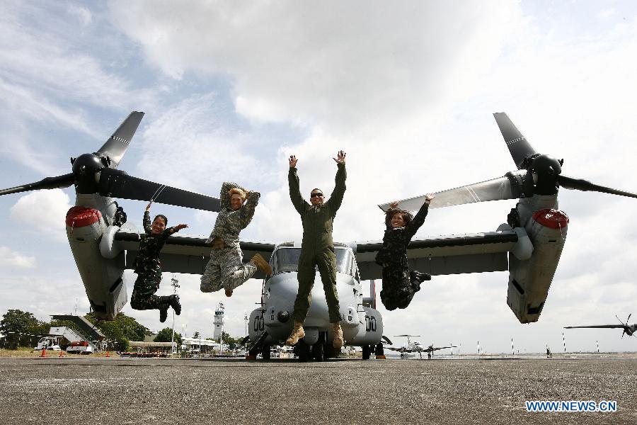 American and Filipino soldiers jump in front of the MV-22 Osprey as they share a light moment during an aircraft static display as part of a joint military exercise in Pampanga Province, the Philippines, April 13, 2013. The Philippines and the U.S. held their 29th annual joint military exercise with at least 8,000 American and Filipino soldiers participating in the training. The joint military exercise, more known as Balikatan, which means "shoulder-to-shoulder" in Filipino, is held from April 5 to 17. (Xinhua/Rouelle Umali)