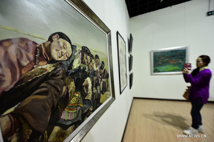 A visitor takes pictures of paintings at an exhibition commemorating the third anniversary of the Yushu earthquake, at the Qinghai Provincial Museum in Xining, capital of northwest China's Qinghai Province, April 14, 2013. A 7.1-magnitude earthquake hit Yushu on April 14, 2010, leaving 2,698 dead and over 12,000 injured.(Xinhua/Wu Gang)  