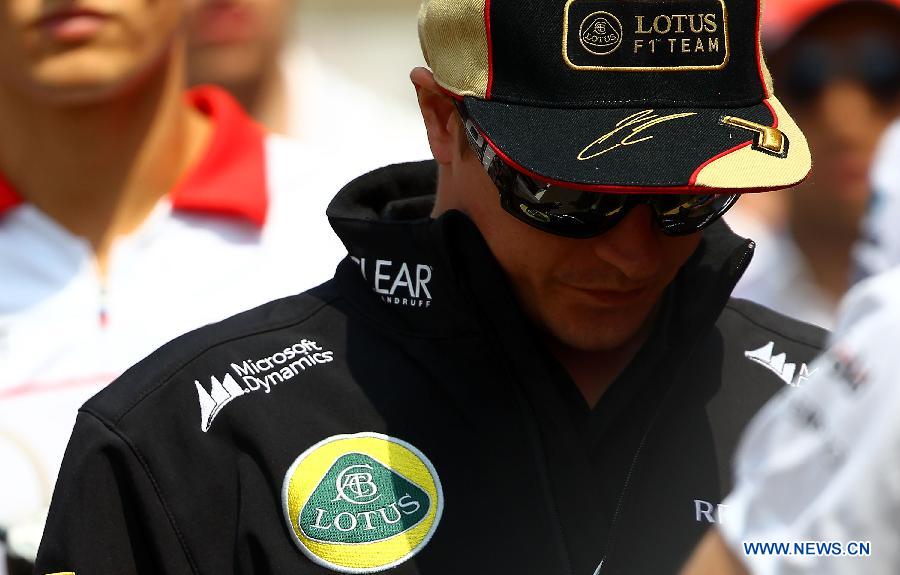 Lotus driver Kimi Raikkonen of Finland reacts after attending the drivers parade prior to the start of the Chinese F1 Grand Prix at the Shanghai International circuit, in Shanghai, east China, on April 14, 2013. (Xinhua/Li Ming)