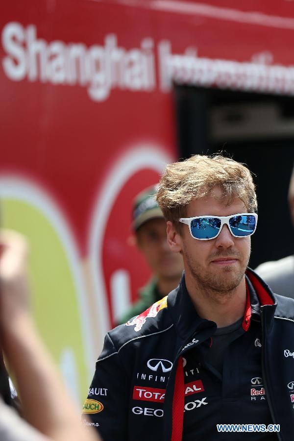 Red Bull driver Sebastian Vettel of Germany reacts after the drivers parade prior to the start of the Chinese F1 Grand Prix at the Shanghai International circuit, in Shanghai, east China, on April 14, 2013. (Xinhua/Li Ming)