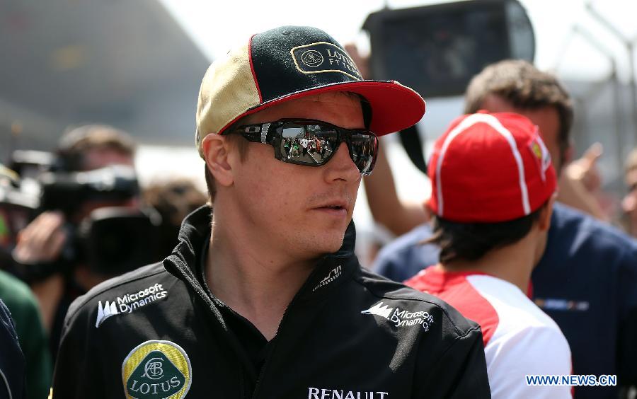 Lotus driver Kimi Raikkonen of Finland reacts after the drivers parade prior to the start of the Chinese F1 Grand Prix at the Shanghai International circuit, in Shanghai, east China, on April 14, 2013. (Xinhua/Li Ming)