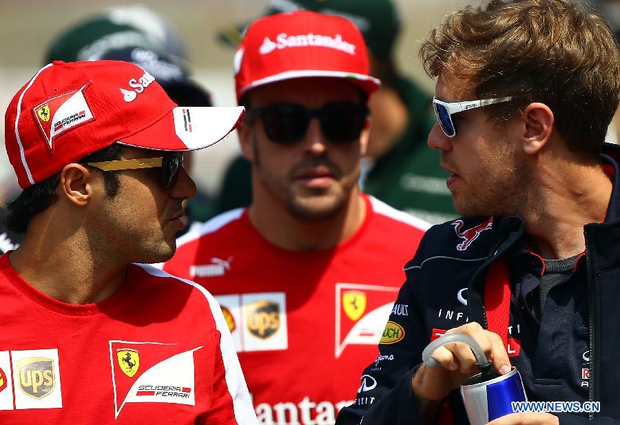 Red Bull driver Sebastian Vettel (R) of Germany talks to Ferrari driver Felipe Massa (L) of Brazil before attending the drivers parade prior to the start of the Chinese F1 Grand Prix at the Shanghai International circuit, in Shanghai, east China, on April 14, 2013. (Xinhua/Li Ming)