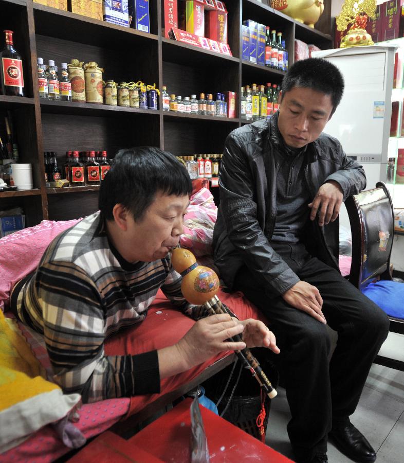 Peng Shuilin plays music for his neighbor. (Xinhua/ Li Ga)