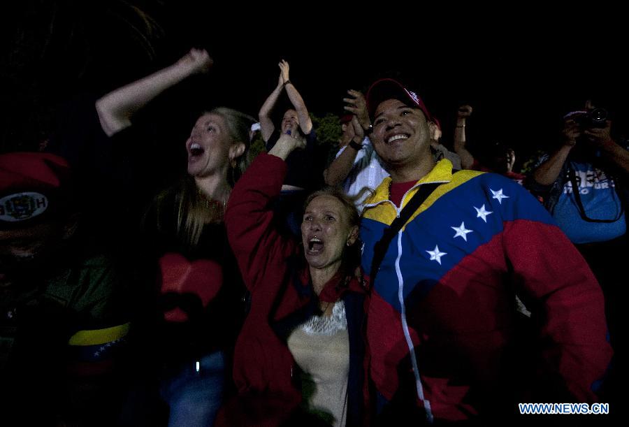 Supporters of Venezuelan acting President Nicolas Maduro celebrate his victory in Caracas, capital of Venezuela, on April 14, 2013. Venezuelan Acting President Nicolas Maduro narrowly won the presidential election with 50.66 percent of the votes, National Electoral Council's President Tibisay Lucena said on Sunday. (Xinhua/David de la Paz)
