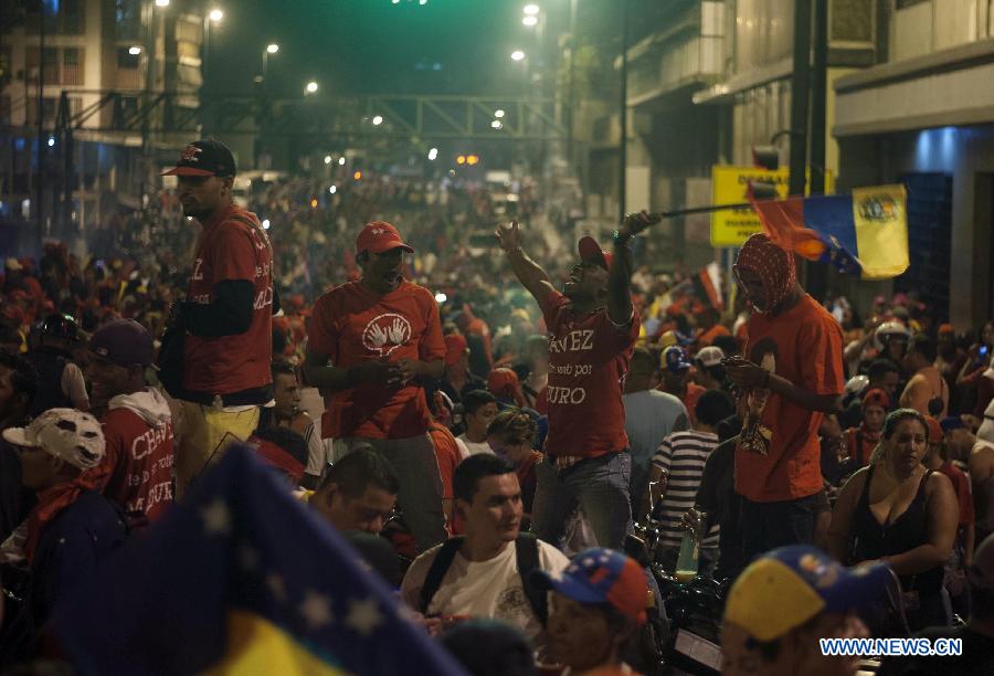 Supporters of Venezuelan acting President Nicolas Maduro celebrate his victory in Caracas, capital of Venezuela, on April 14, 2013. Venezuelan acting President Nicolas Maduro narrowly won the presidential election with 50.66 percent of the votes, National Electoral Council's President Tibisay Lucena said on Sunday. (Xinhua/Mauricio Valenzuela)