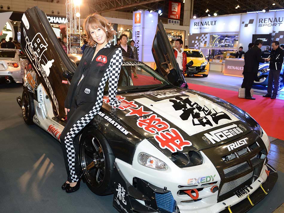 A models poses next to a modified car at the Tokyo modified car show on Jan 11, 2013 in Tokyo. (Photo / Xinhua)