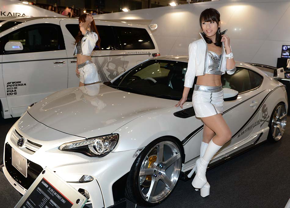 Models pose next to a modified Lamborghini car at the Tokyo modified car show on Jan 11, 2013 in Tokyo. (Photo / Xinhua) 