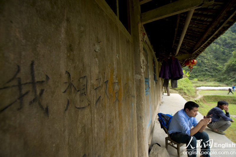 Yu Qiyun has written in Chinese charaters "I want to change roads" on the wall of his house, Sangzhi county, Hunan province April 11, 2013. (Photo/ People's Daily Online)