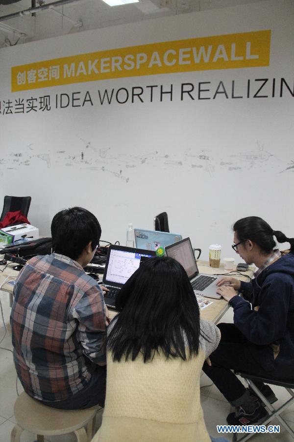Makers gather to program for their products during the Art and Tech Hackathon, an innovation competition organized by a hackerspace Beijing Maxpace, in Beijing, capital of China, April 14, 2013. Some 23 makers participated in the competition. (Xinhua/Ma Ping)