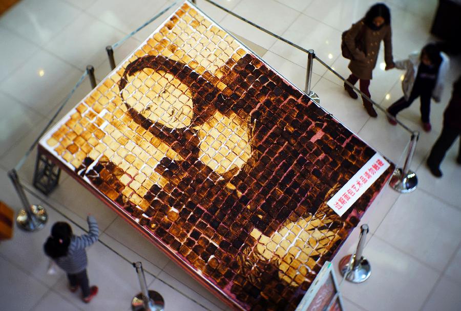 People look at a "Mona Lisa" portrait made from expired bread in a shopping mall in Tianjin, April 14, 2013. (Xinhua/You Sixing)