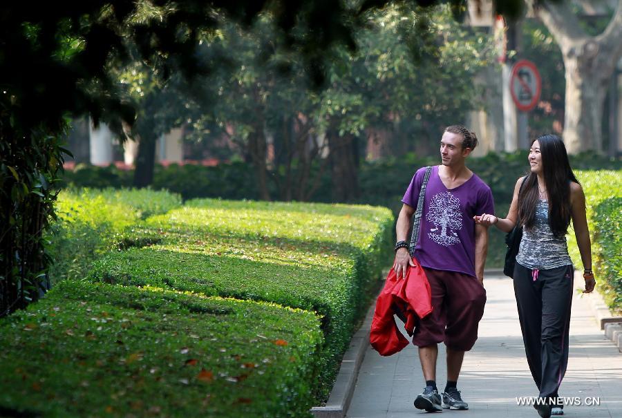 Tourists walk in Xuhui District of Shanghai, east China, April 15, 2013. The temperature in Shanghai's Xujiahui area reached 30.2 degrees Celsius due to a warm air mass over it on Monday, according to local meteorological station. (Xinhua/Pei Xin) 