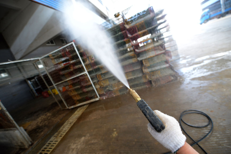 A health worker sprays disinfectant at a closed live poultry trade market in Feidong county, east China's Anhui province on April 7, 2013. (Xinhua/Zhang Duan)