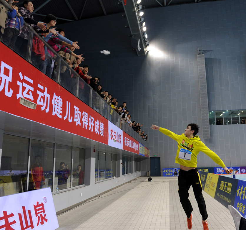 Sun Yang throws his swimming cap to the spectators to celebrate his victory of men's 1,500-meter freestyle champion in the preselection of National Games on April 8,  2013. (Photo by Li Bo/ Xinhua)