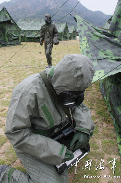 A shore-based mobile anti-ship-missile regiment under the South China Sea Fleet of the Navy of the Chinese People's Liberation Army (PLA) organized a NBC (nuclear, biological and chemical) defense drill against actual-combat background on April 7, 2013. The picture shows the officers and men of the regiment are carrying out decontamination and detection of chemical agents in the infected "toxic" areas. (China Military Online/Sheng Yuehua, Zhao Changhong and Zheng Can)