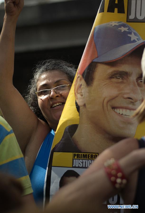 A supporter of opposition leader Henrique Capriles takes part in a protest, in front of his campaign headquarters, in Caracas, capital of Venezuela, on April 15, 2013. The Venezuelan National Electoral Council (CNE) said the "irreversible" result in Sunday's special election gave Acting President Nicolas Maduro the victory over Henrique Capriles. Capriles has said he will not recognize the outcome until a full recount is performed. Maduro has said he is open to a full audit of the results. (Xinhua/Mauricio Valenzuela)