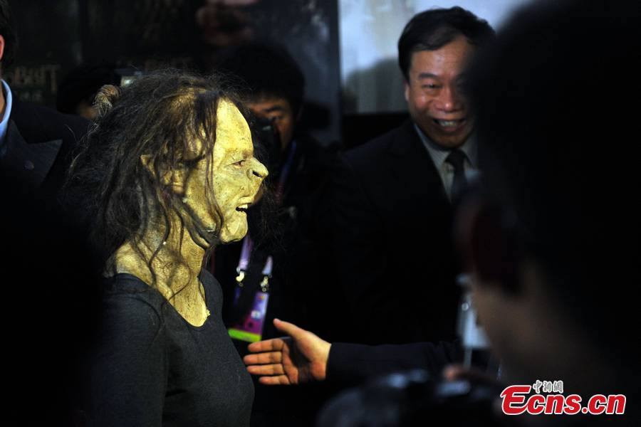 A make-up artist demonstrates special effects makeup to movie fans during a film carnival at the Olympic Green in Beijing, April 16, 2013. The carnival that helped heat up excitement of the 3rd Beijing International Film Festival offers movie-goers fresh experiences to learn some of the mystery behind the silver screen.(CNS/Jin Shuo)