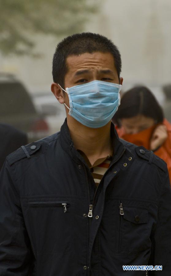 A pedestrian wears a mask while walking amid floating dust and sand storm in Kashgar, northwest China's Xinjiang Uygur Autonomous Region, April 16, 2013. Gales with dust began to hit Kashgar on Tuesday and will last for four days, according to meteorological authority forecast. (Xinhua/Zhao Ge)
