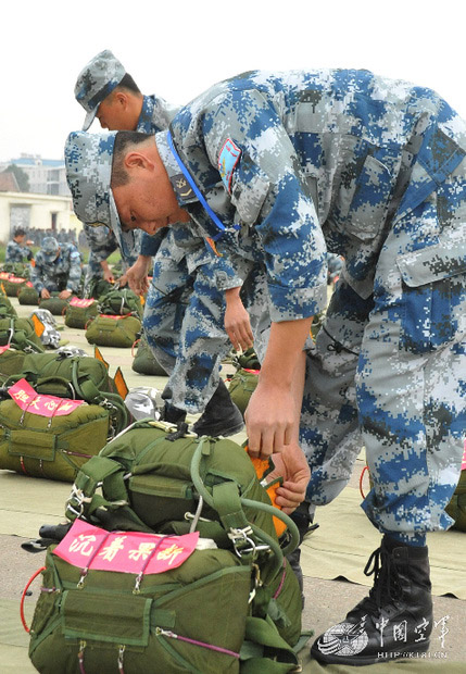 The instructors carefully check the parachute. (China Military Online/Liu Jilu)