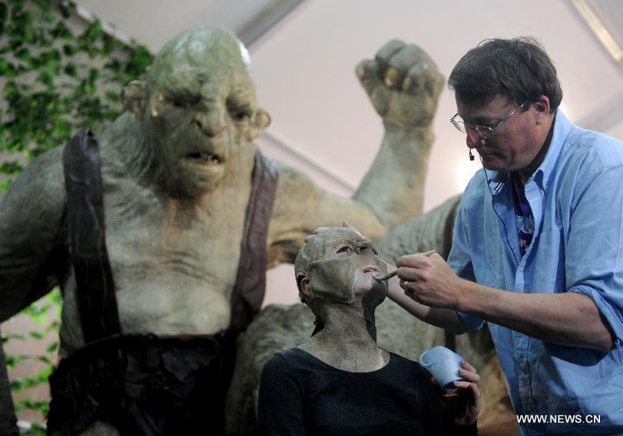Richard Taylor (1st R), creator and head of New Zealand film prop and special effects company Weta Worshop, dresses up a monster movie figure at the film carnival of the 3rd Beijing International Film Festival in Beijing, capital of China, April 16, 2013. The movie carnival kicked off here on Tuesday. (Xinhua/Luo Xiaoguang)