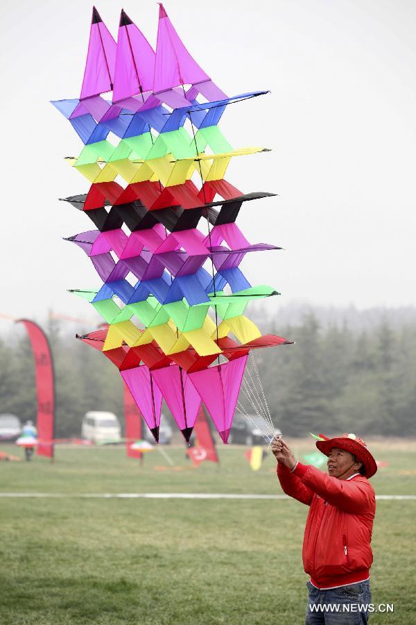 A contestant tries to fly a kite during a competition of flying kites in Weifang, east China's Shandong Province, April 6, 2013. A total of teams of contestants were involved and 1,164 kites were displayed on the event here on Tuesday. (Xinhua/Zhang Chi) 