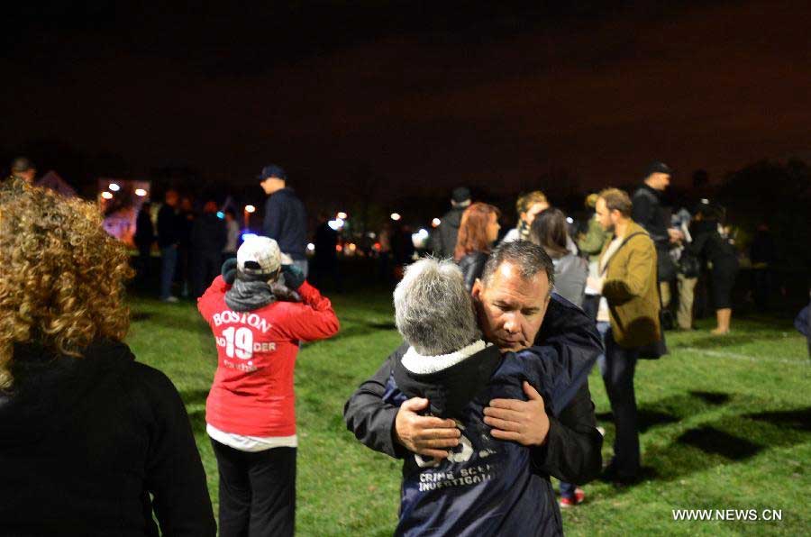 Citizens hug each other during a vigil for the victims in Boston Marathon blasts in Boston, the United States, April 16, 2013. The death toll has risen to three, with 176 people injured. (Xinhua/Wang Lei) 