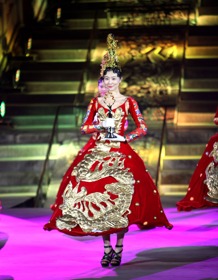 A model dressed in a vivid China Red dress with golden dragon prints presents the "Tiantan Award" to audiences at the Opening Ceremony of the 3rd Beijing International Film Festival, at the Hall of Prayer for Good Harvests in the Temple of Heaven Park on Tuesday, April 16, 2013. [CRIENGLISH.com, Photo: Zhang Linruo]