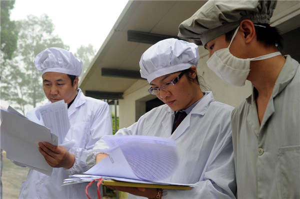 Staff members from Guangdong Entry-Exit Inspection and Quarantine Bureau examine poultry breeding farm records in Guangzhou, on April 16, 2013. The bureau is taking measures to ensure the safety of poultry supplied to Hong Kong and Macao, such as examining registered poultry breeding farms, monitoring pathogens of bird flu, and inspection of live poultry before export. As of April 16, no H7N9 cases were found in the 39 registered poultry breeding farms under the bureau's jurisdiction. [Photo/Xinhua] 