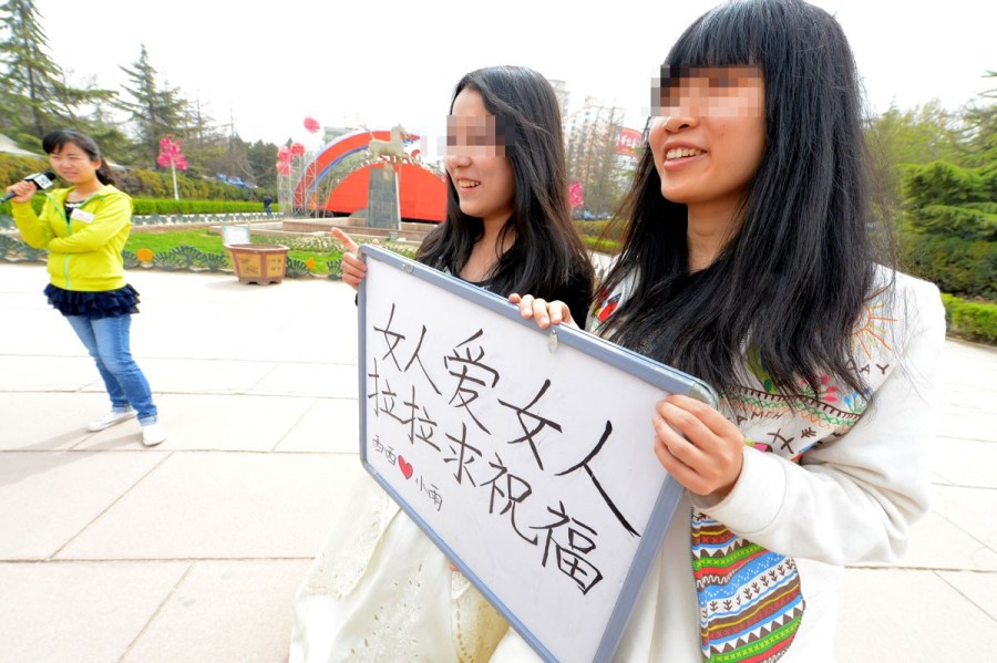 Lesbian lovers hold a wedding ceremony in a park of Lanzhou on April 15, 2012. They held a sign reading "Woman loves woman, lesbians need bless" to call for tolerance of homosexual marriage. 