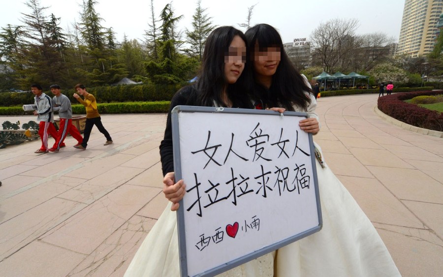 Lesbian lovers hold a wedding ceremony in a park of Lanzhou on April 15, 2012. They held a sign reading "Woman loves woman, lesbians need bless" to call for tolerance of homosexual marriage. 