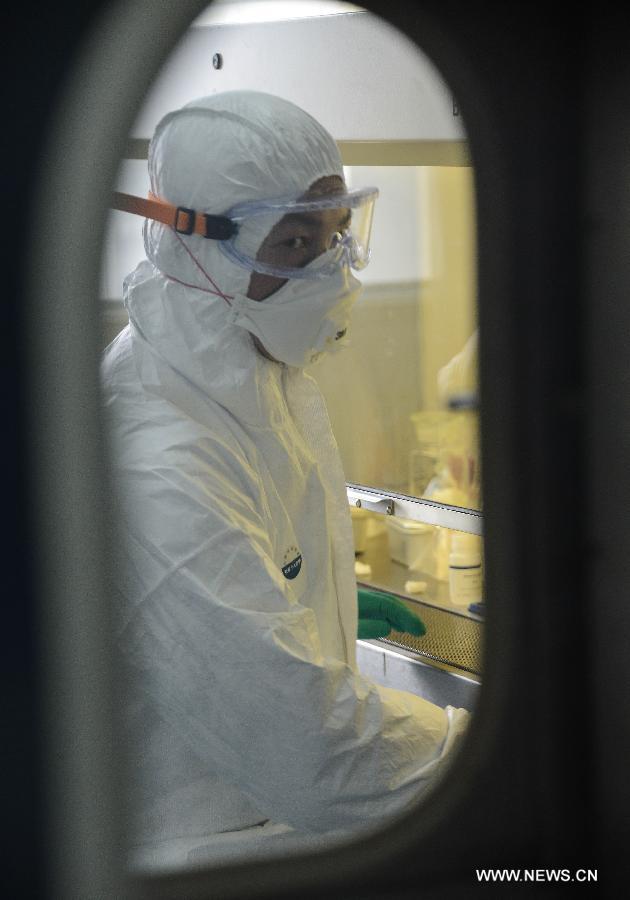 A researcher in protective suit collects samples of a suspected case of the H7N9 avian influenza virus for testing at the provincial center for disease control and prevention in Hangzhou, capital of east China's Zhejiang Province, April 17, 2013. An emergent testing team on 24-hour stand-by was set up in the center after the recent spread of the H7N9 virus. Infections within the province will be officially confirmed by the center. (Xinhua/Xu Yu)