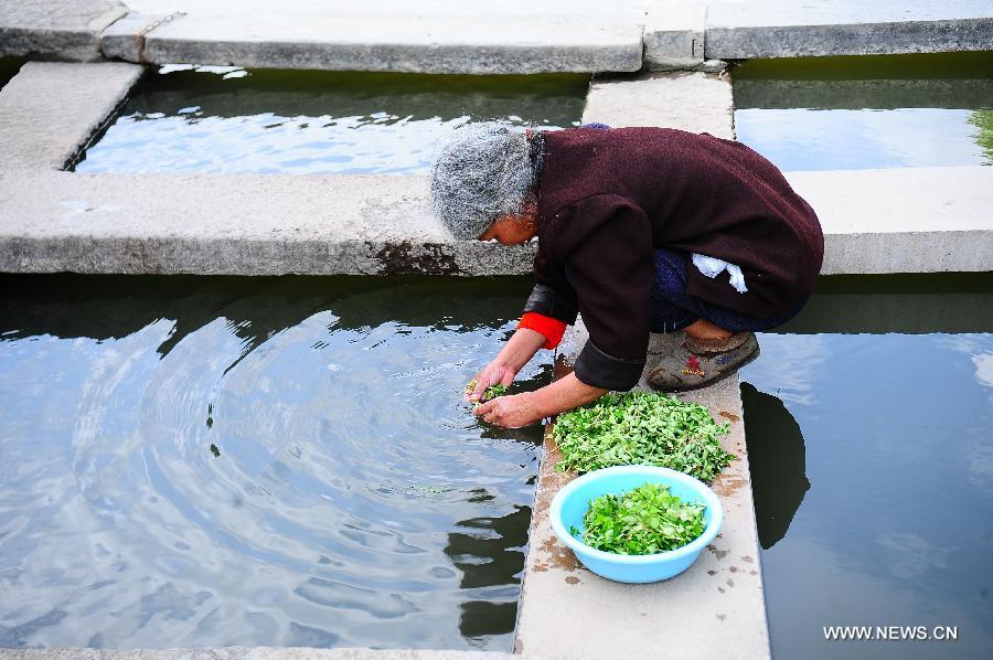 A local resident wash vegetables in ancient townlet Heshun in Tengchong County, southwest China's Yunnan Province, April 16, 2013. The townlet, featuring time-honored temples and houses, is located three kilometers away from the county seat of Tengchong, where live 6,000 people. (Xinhua/Qin Lang)