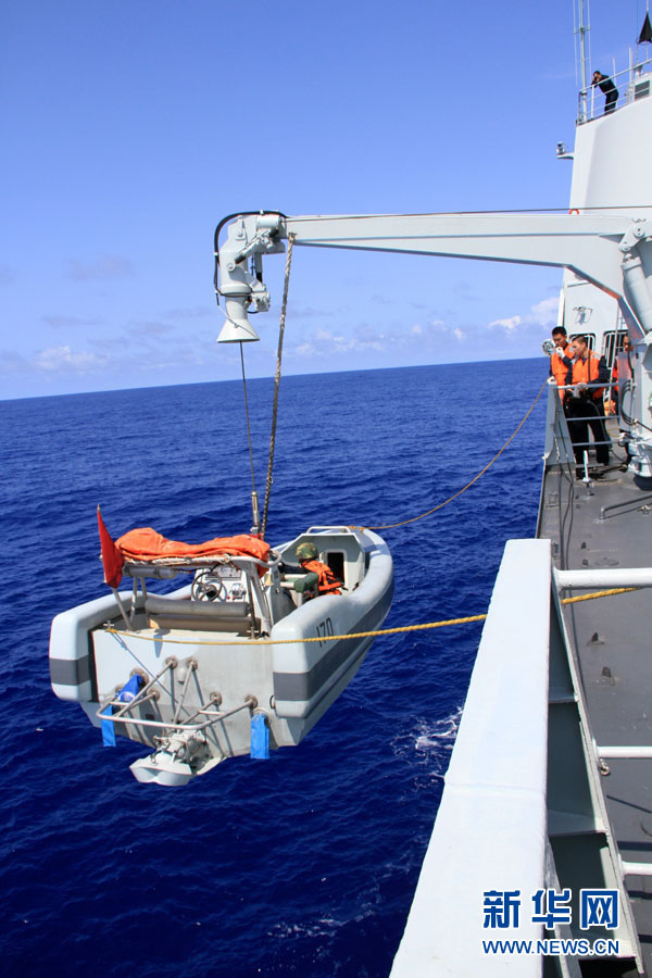 The crane of the "Lanzhou" warship is lifting a small boat into the sea. (Xinhua/Yang Lei)