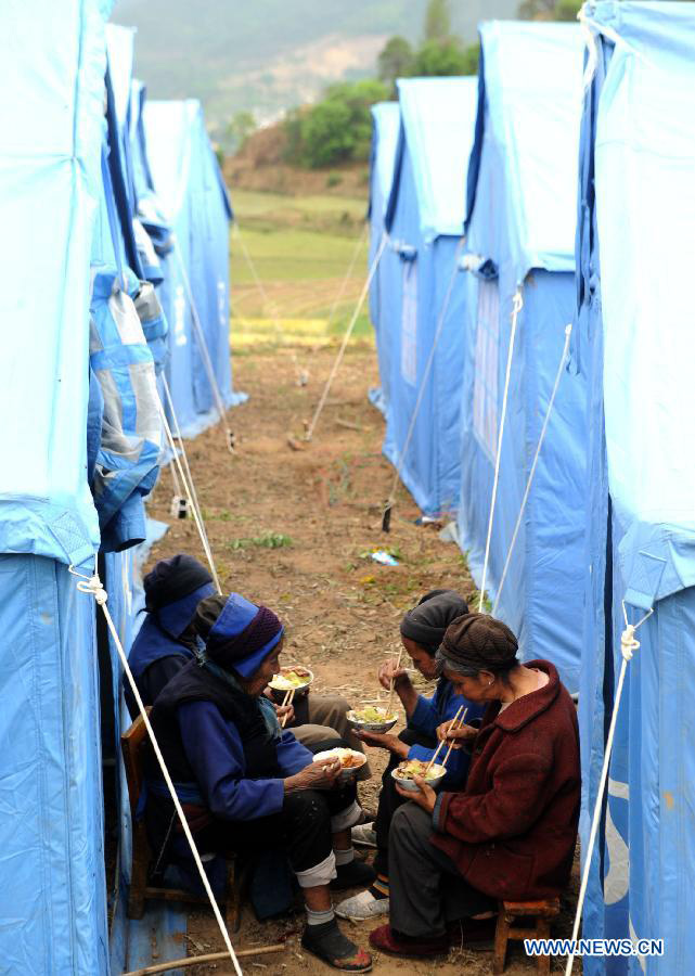 Local residents have dinner by their shelter tents at a settlement site at Changyi Village of Liantie Township in Eryuan County under Dali Bai Autonomous Prefecture, southwest China's Yunnan Province , April 17, 2013. A 5-magnitude earthquake jolting Dali Wednesday morning has affected 123,000 people. (Xinhua/Chen Haining)