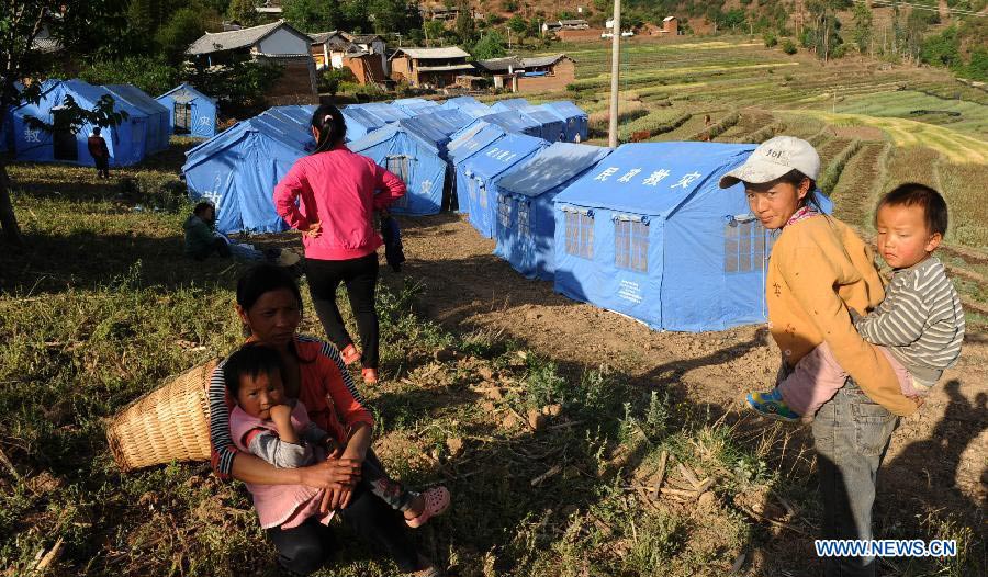 Evacuated villagers are seen by their shelter tents at a settlement site at Changyi Village of Liantie Township in Eryuan County under Dali Bai Autonomous Prefecture, southwest China's Yunnan Province , April 17, 2013. A 5-magnitude earthquake jolting Dali Wednesday morning has affected 123,000 people. (Xinhua/Chen Haining)