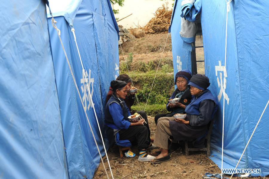 Local villagers have dinner by their shelter tents at a settlement site at Changyi Village of Liantie Township in Eryuan County under Dali Bai Autonomous Prefecture, southwest China's Yunnan Province , April 17, 2013. A 5-magnitude earthquake jolting Dali Wednesday morning has affected 123,000 people. (Xinhua/Chen Haining)