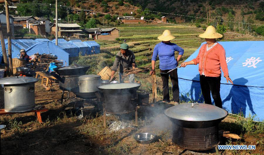 Local residents cook food by their shelter tents at a settlement site at Changyi Village of Liantie Township in Eryuan County under Dali Bai Autonomous Prefecture, southwest China's Yunnan Province , April 17, 2013. A 5-magnitude earthquake jolting Dali Wednesday morning has affected 123,000 people. (Xinhua/Chen Haining)