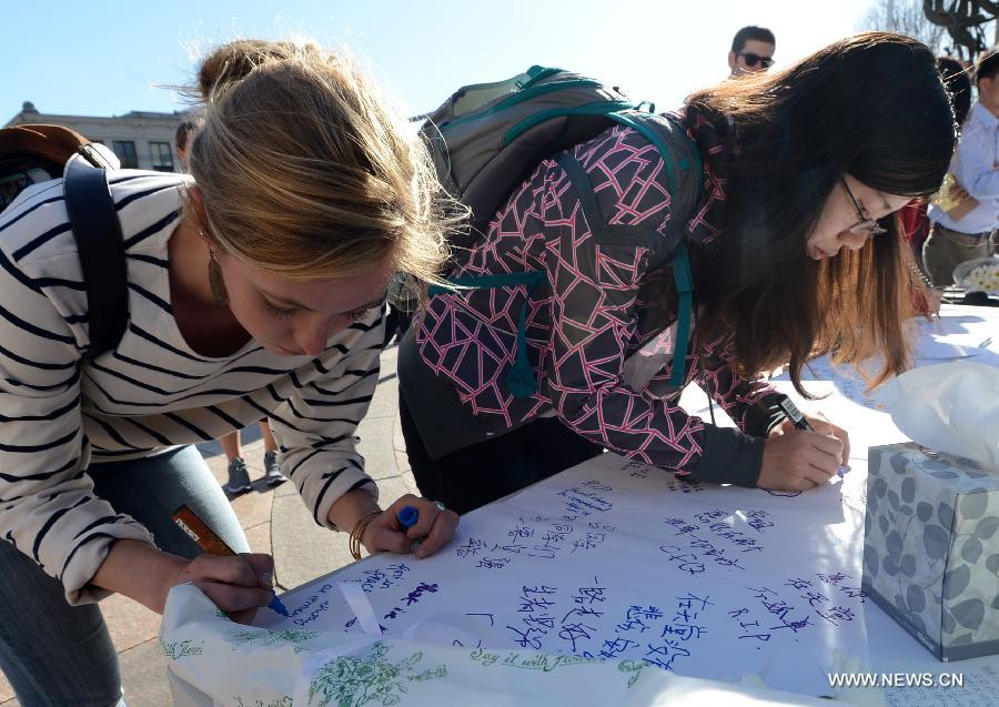 Students sign their names to express condolence to the Chinese victim in Boston Marathon blasts at Boston University in Boston, the United States, April 17, 2013. (Xinhua/Wang Lei) 
